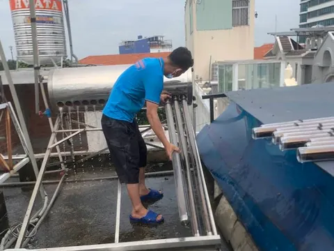 Kỹ thuật viên đang vệ sinh máy nước nóng năng lượng mặt trời