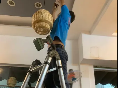 Kỹ thuật viên sửa điện trên trần